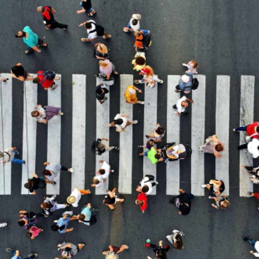Aerial. People crowd motion through the pedestrian crosswalk.
