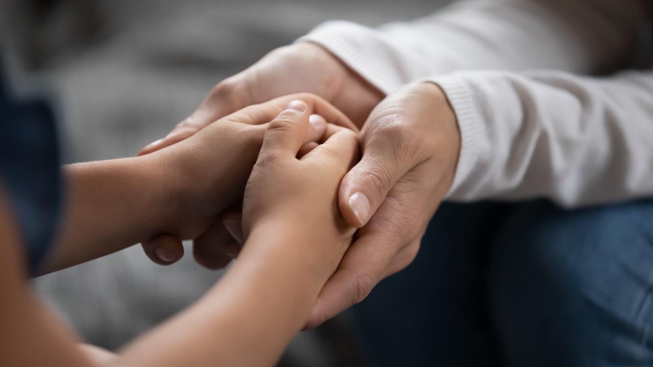 adult hands hold child's hands