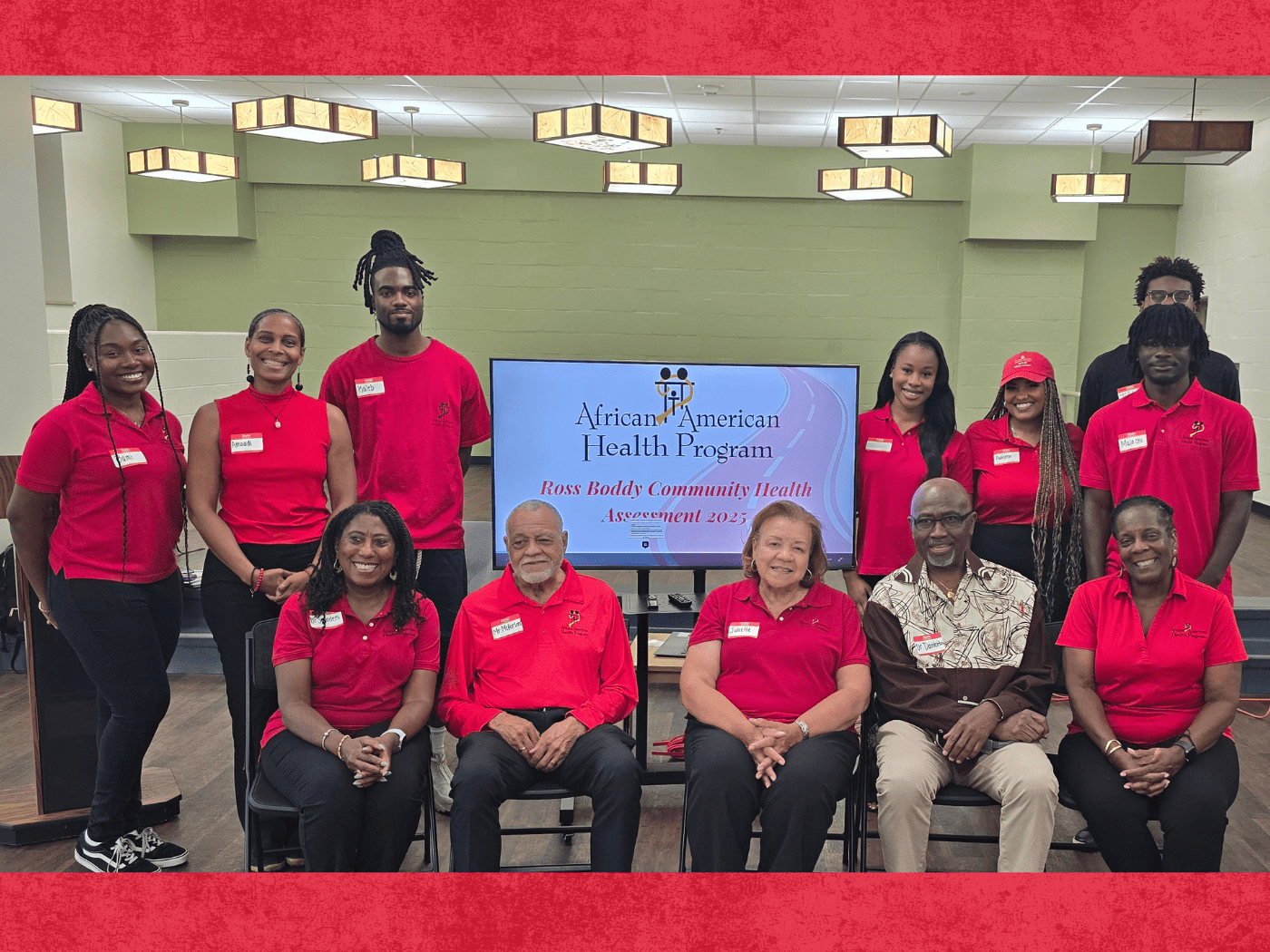 group of student interns and community members pose for the camera with African American Health Program sign