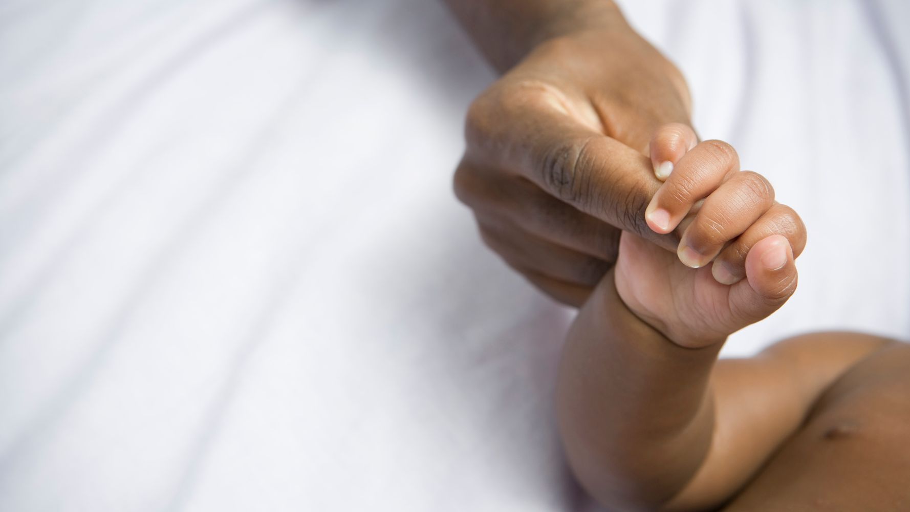 Baby hand being held by adult