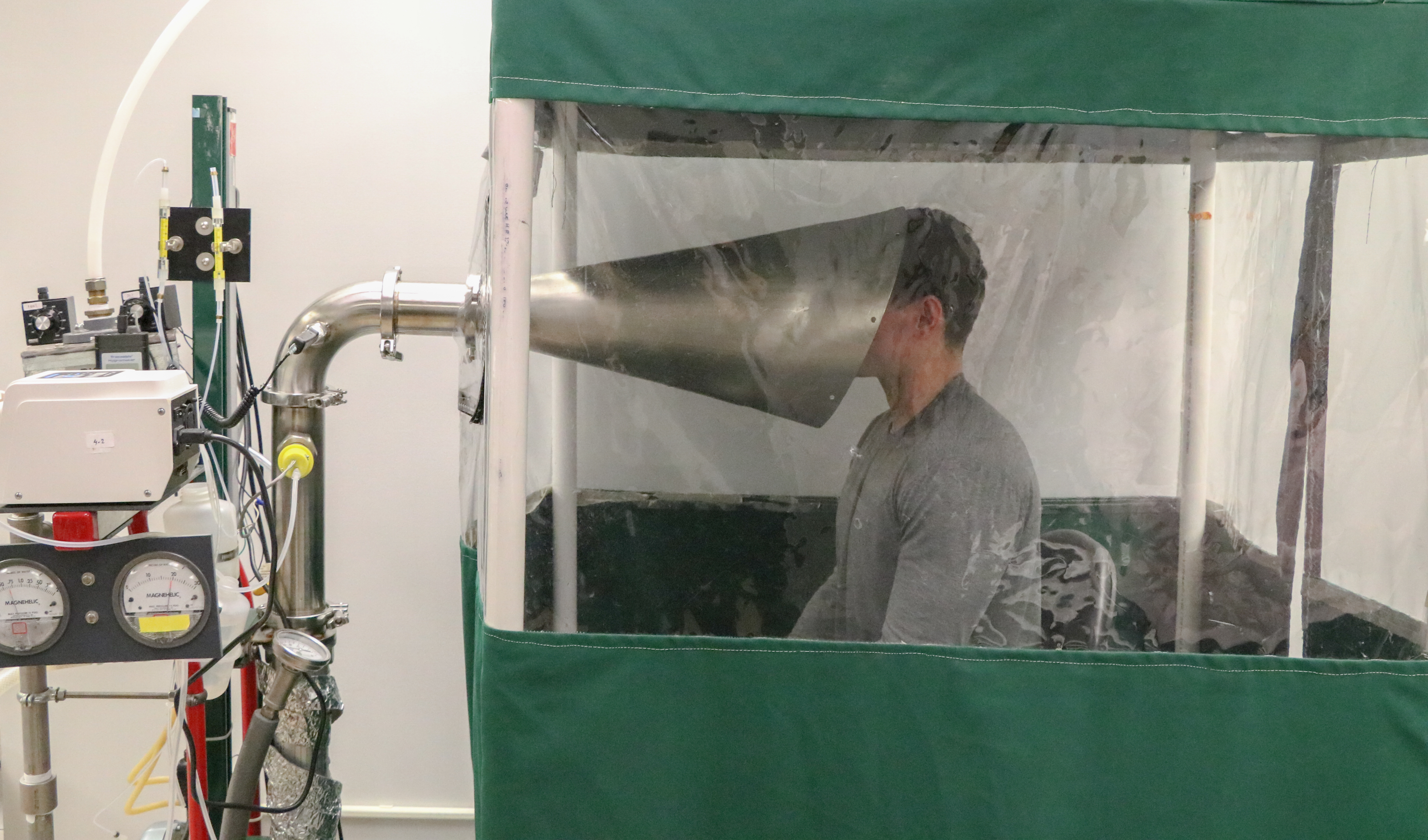 A student puts his head in a machine created by Dr. Don Milton