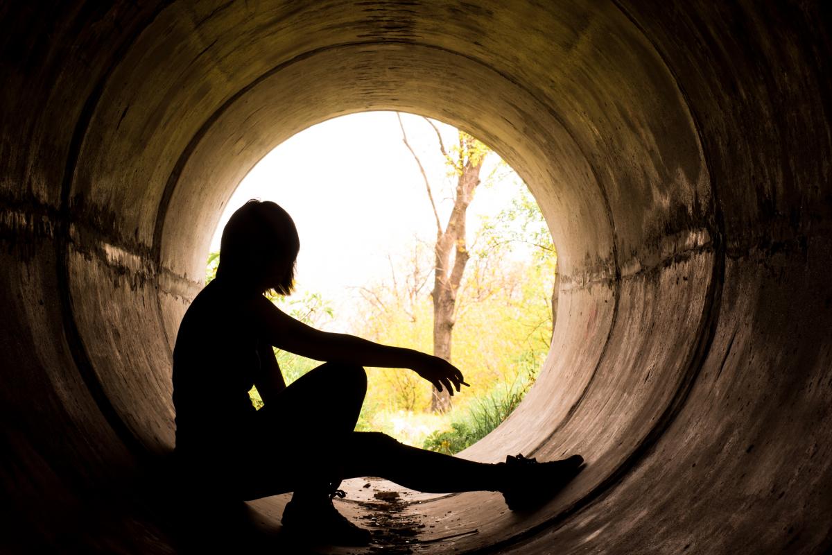 Young woman sitting in tunnel