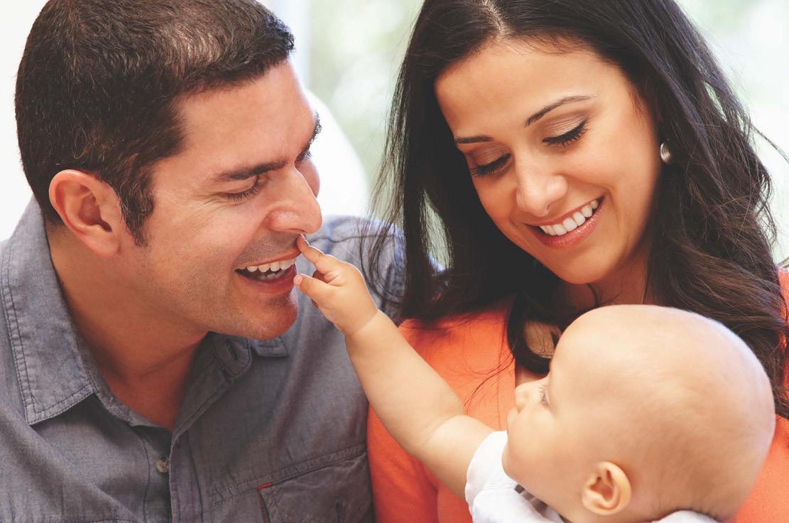 father and mother smiling and holding their baby