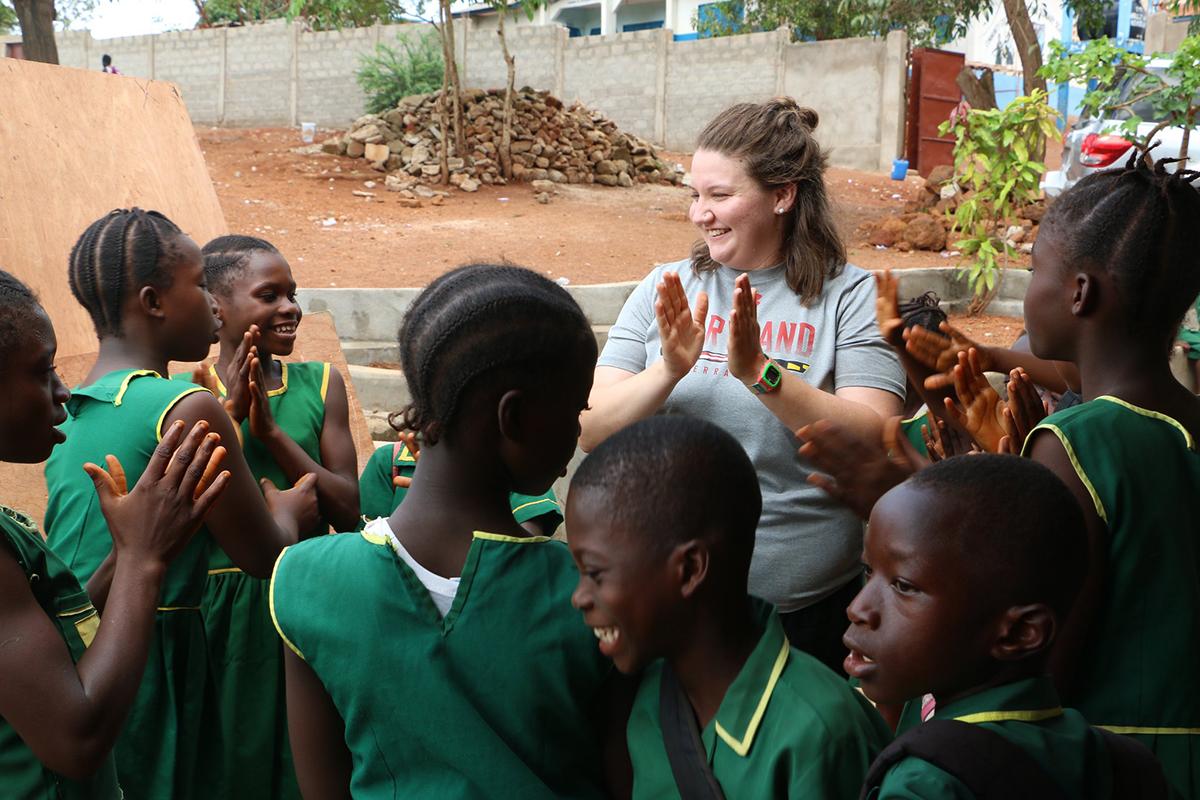 UMD student singing and clapping with school children in Sierra Leone