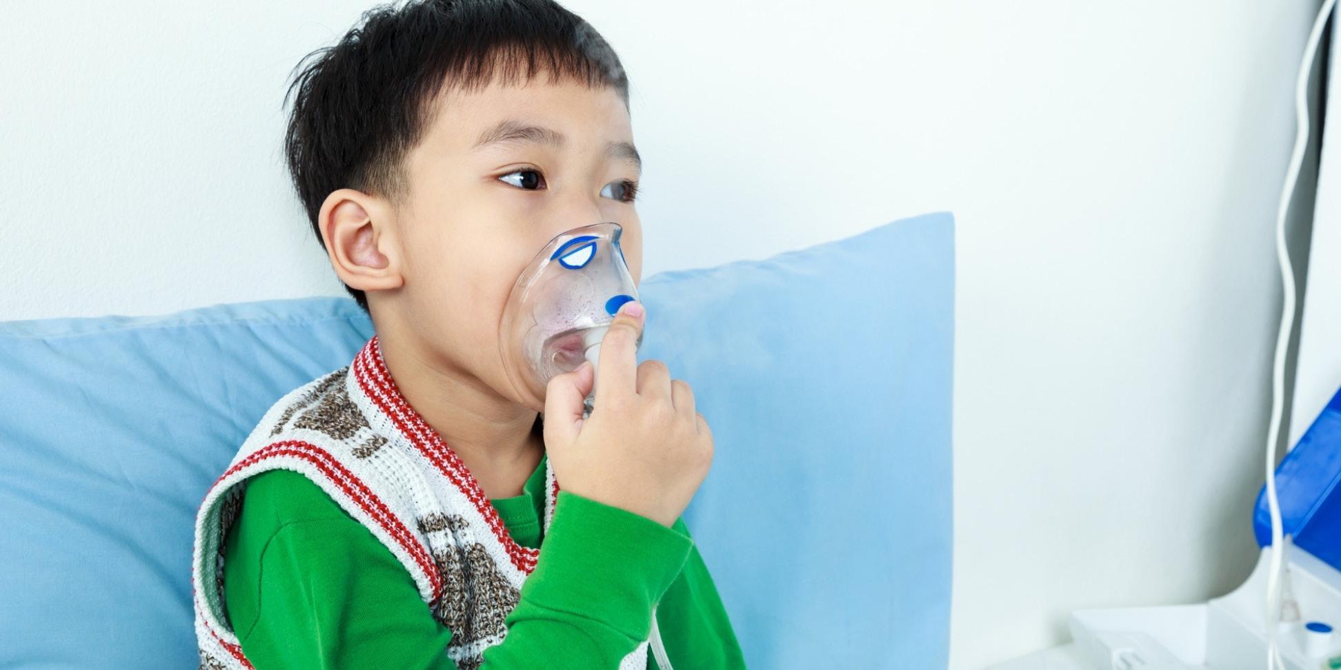 Child holding an oxygen mask