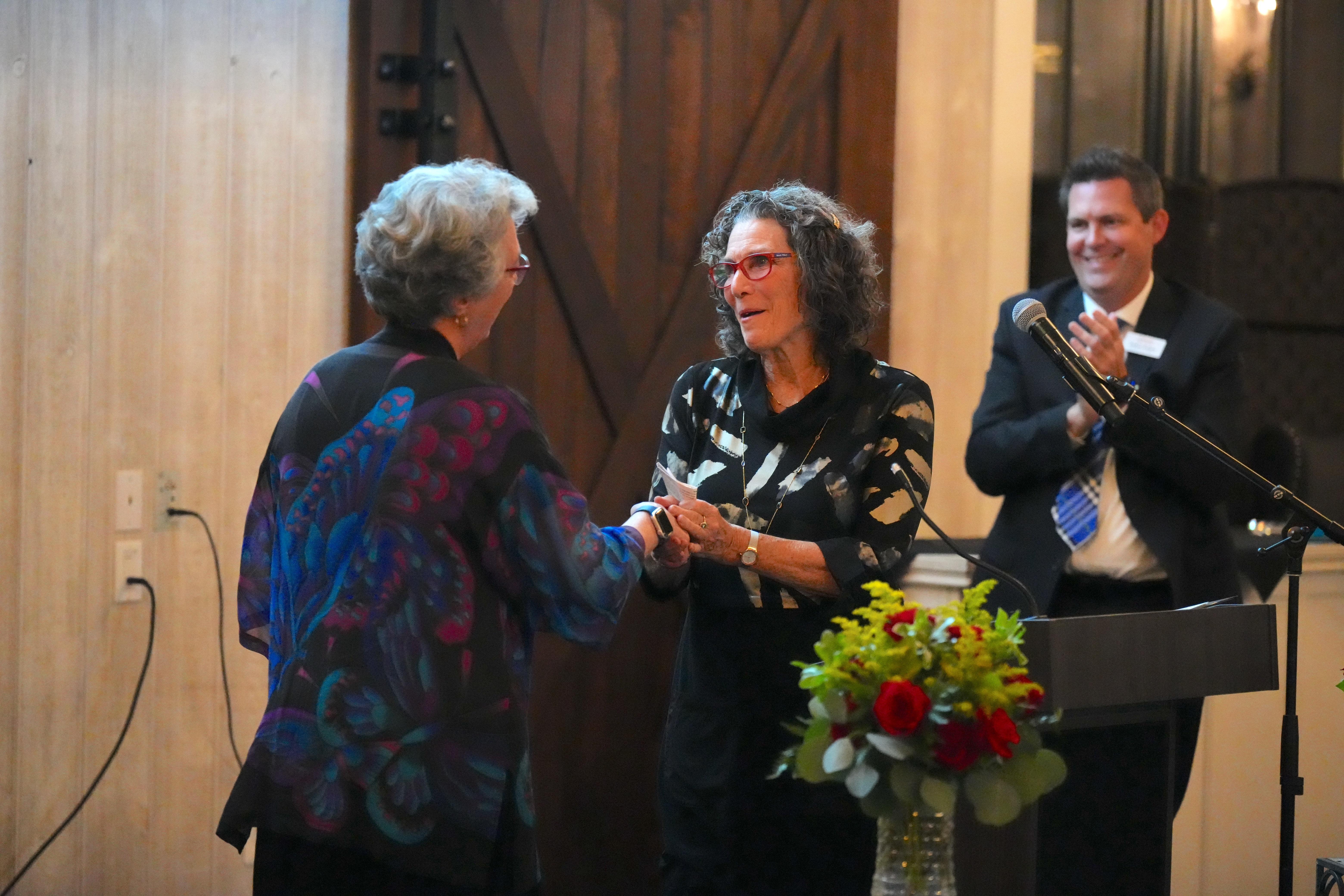 Sandra Crouse Quinn receives an award from Dr. Wendy Miller